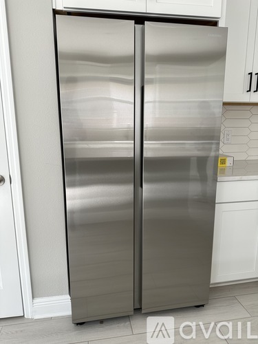 A stainless steel double door refrigerator in a kitchen.