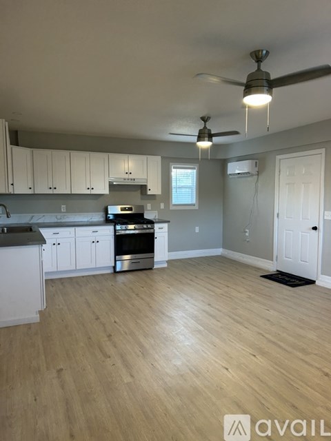 A kitchen with white cabinets and a wooden floor.