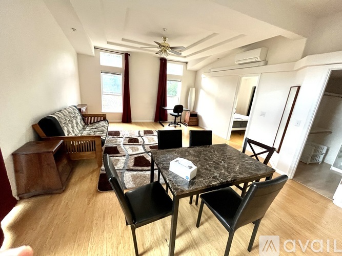 A living room with a couch, chairs, and a dining table.