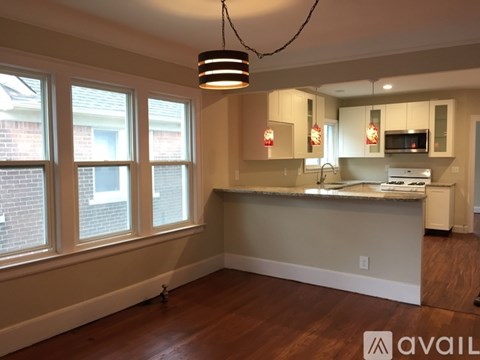 A kitchen with a large island and pendant lights.