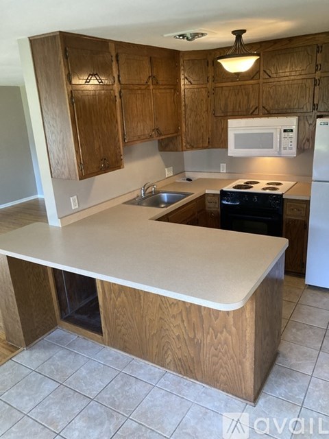 A kitchen with wooden cabinets and a white refrigerator.