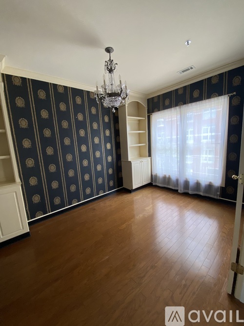 A room with a chandelier and a wooden floor.