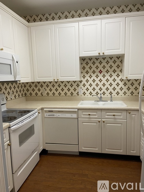 A kitchen with white cabinets and a patterned backsplash.