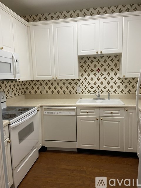 A kitchen with white cabinets and a patterned backsplash.