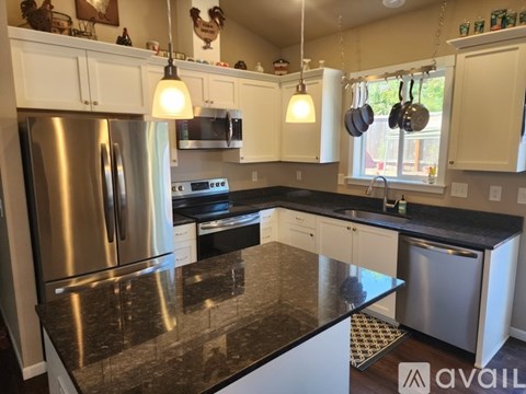 A kitchen with granite countertops and stainless steel appliances.