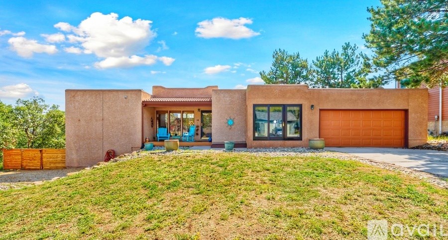 A modern house with a brown exterior and a large front yard.