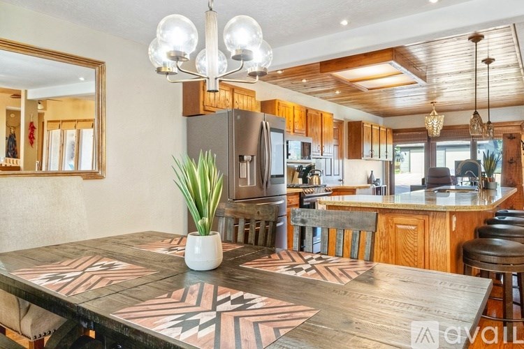 A kitchen with a wooden table and a plant on it.