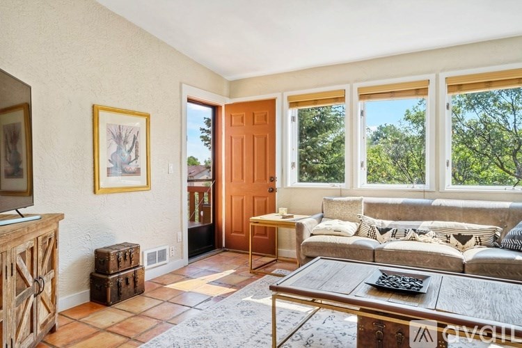 A living room with a brown wooden coffee table and a grey sofa with pillows.