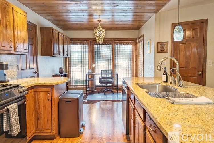 A kitchen with wooden cabinets and a granite countertop.