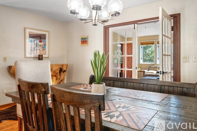 A dining room with a wooden table and chairs.