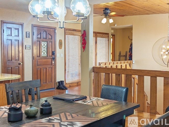 A dining room with a wooden table and chairs.