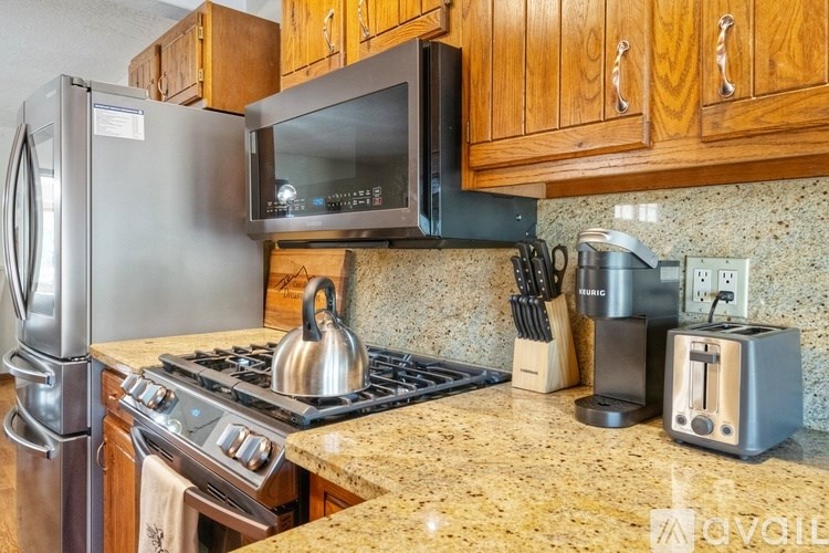 A kitchen with a stove top oven, microwave, toaster, and coffee maker.