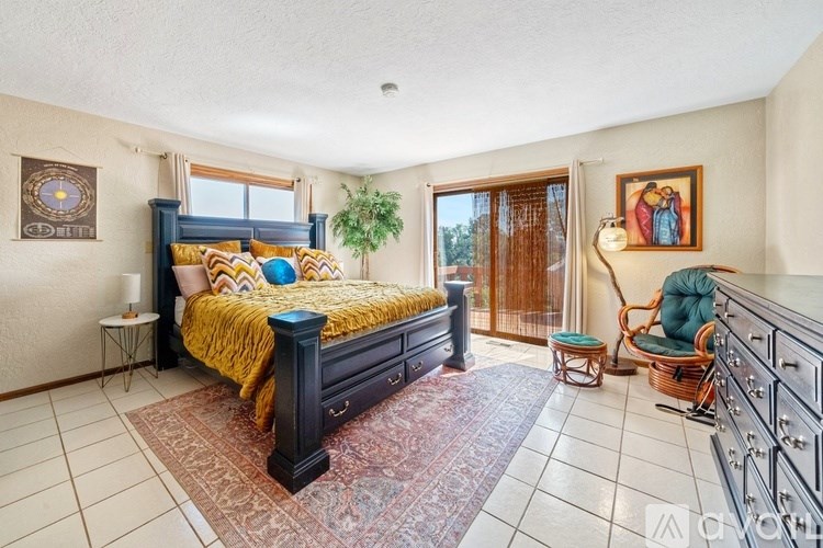 A bedroom with a large bed and a chair.