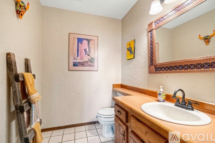 A bathroom with a wooden towel rack and a white toilet.