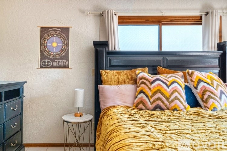 A bedroom with a large bed and a wall hanging.