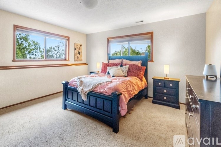 A bedroom with a bed, nightstand, and window.