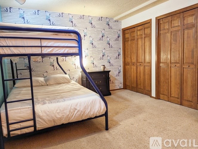 A bedroom with a bunk bed and wooden wardrobes.