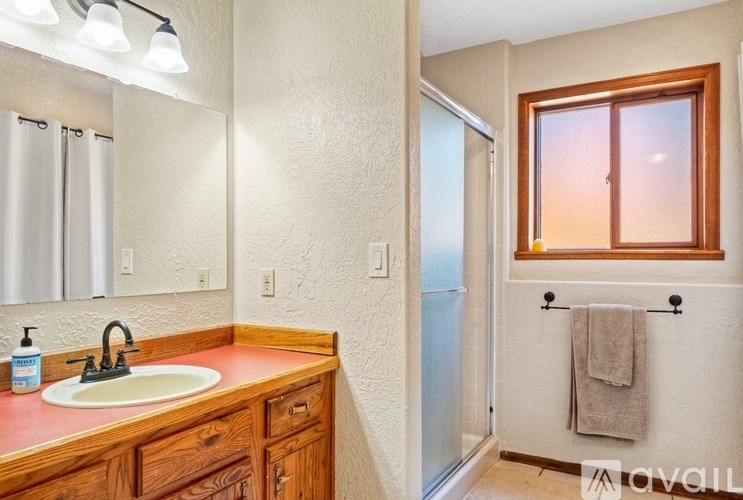 A bathroom with a sink, mirror, and towel rack.