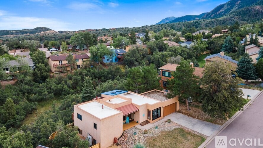 A bird's eye view of a house surrounded by other houses and trees.
