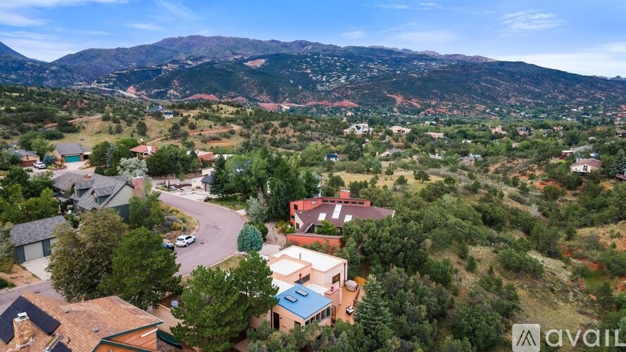 A bird's eye view of a residential area with houses and a car parked in the driveway.