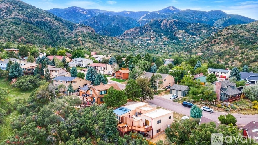 A bird's eye view of a mountainous residential area with houses and greenery.