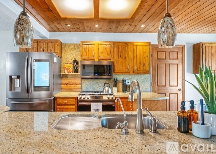 A kitchen with wooden cabinets and a granite countertop.