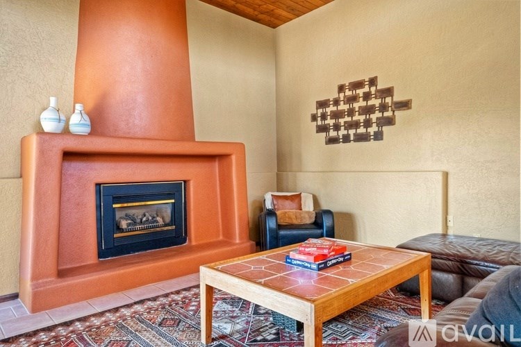 A living room with a fireplace and a brown coffee table.