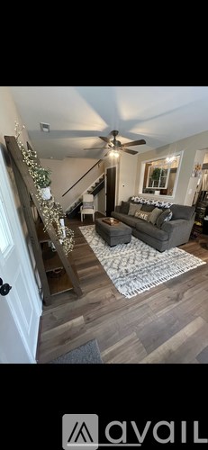 A living room with a couch and a ceiling fan.