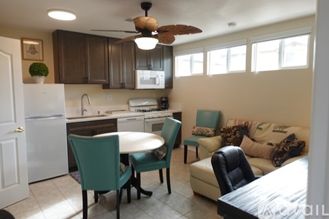 A kitchen with a table and chairs in front of a refrigerator.