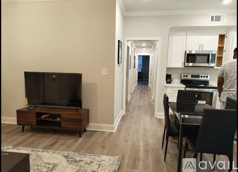 A living room with a television and a dining area.