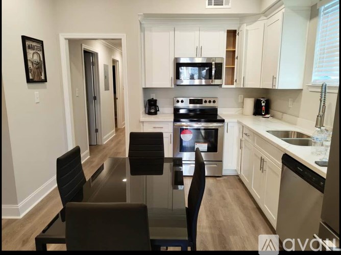A kitchen with white cabinets and a black table.