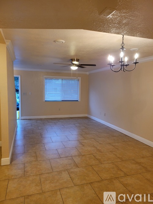 A room with a ceiling fan and a chandelier.