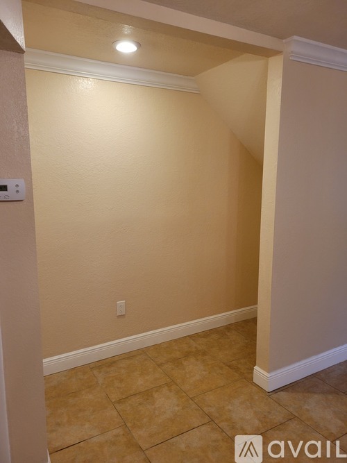 A room with beige walls and tiled flooring.