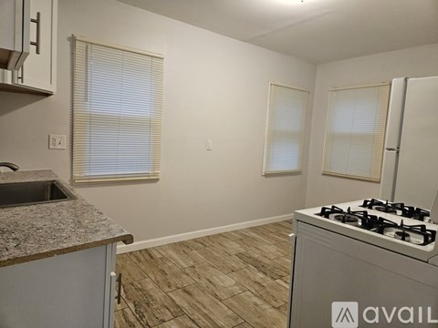 A kitchen with a granite countertop and a stove top oven.
