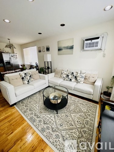 A living room with a white couch and a patterned rug.