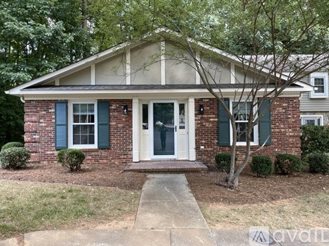 A house with a white door and green shutters.