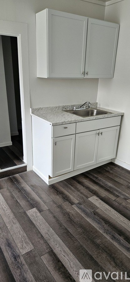 A kitchen with white cabinets and a marble countertop.