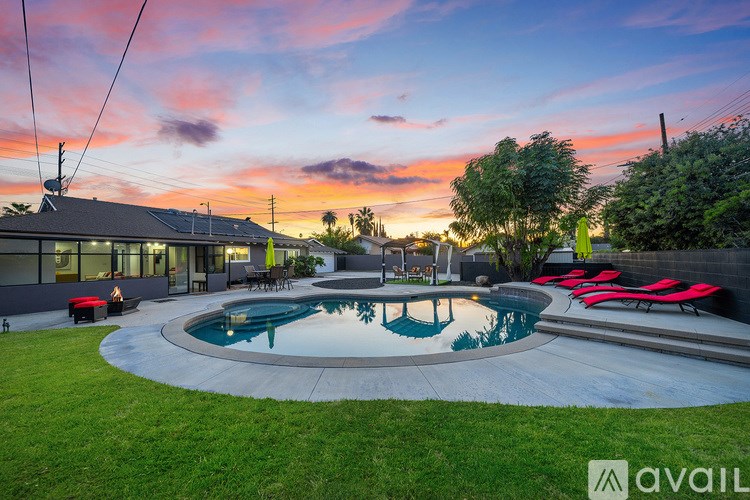 A backyard with a pool and a house with a balcony.