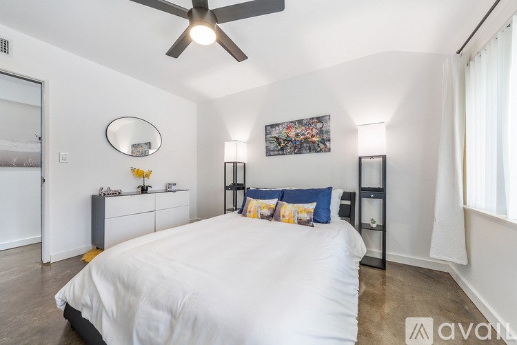A bedroom with a large bed and a ceiling fan.