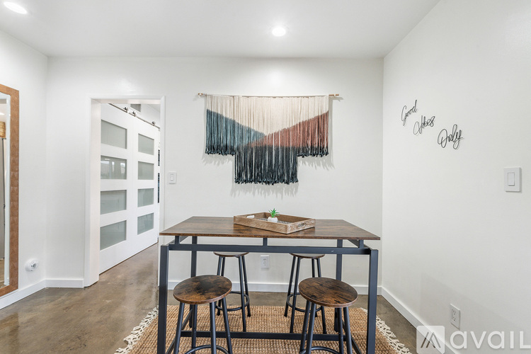 A dining room with a wooden table and two chairs.