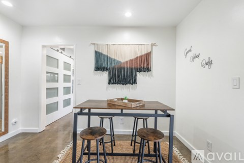 A dining room with a wooden table and two chairs.