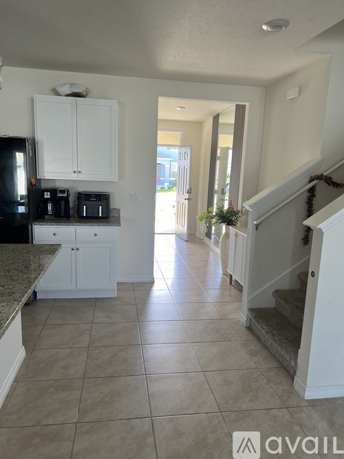 A kitchen with white cabinets and a granite countertop.