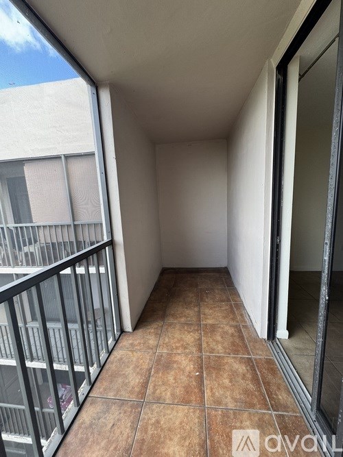 A balcony with tiled flooring and a metal railing.