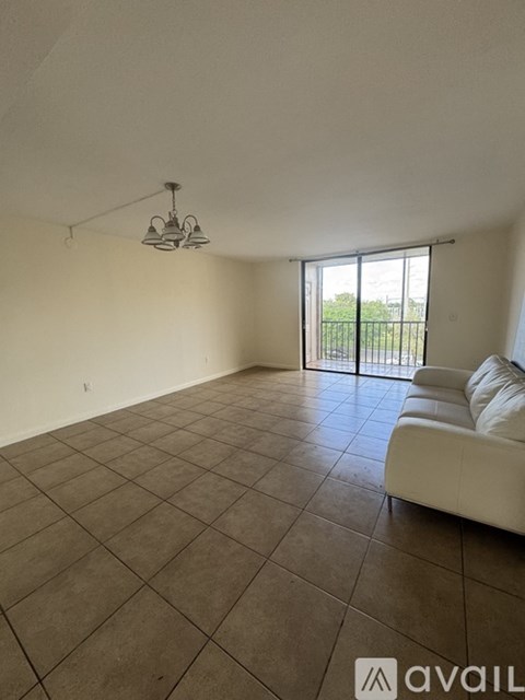 A living room with a white couch and a sliding glass door.