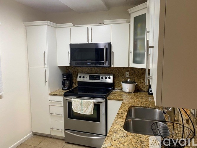 A kitchen with a stove, microwave, and oven.