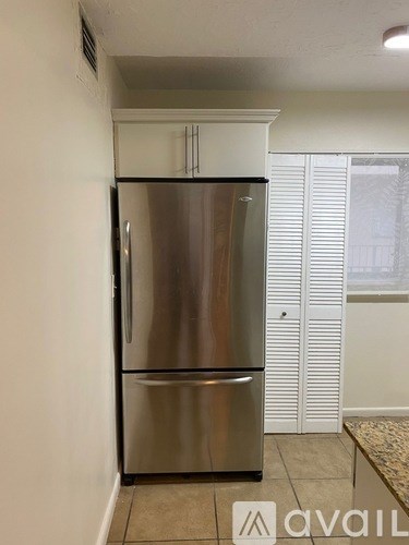 A stainless steel refrigerator in a kitchen.