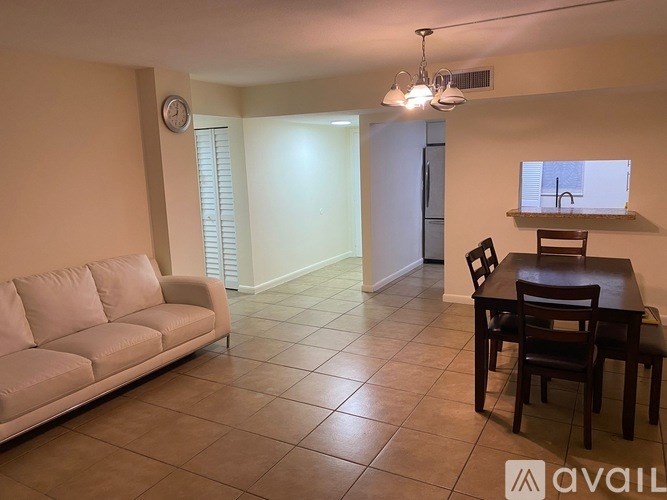 A living room with a couch, table, and chairs.