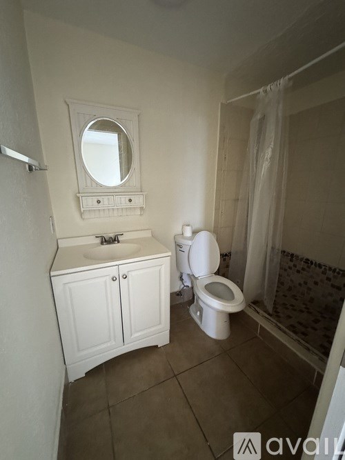 A bathroom with a toilet, sink, and mirror.