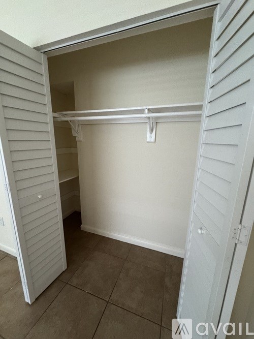 A white closet with a shelf and a hanger.