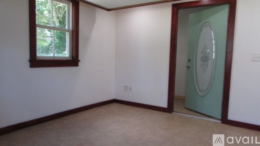 A room with a window and a door is available for rent.
